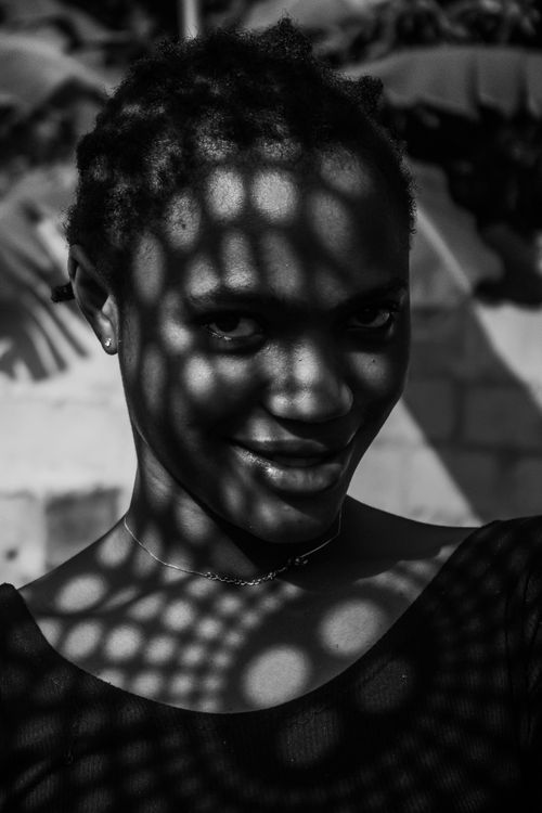 Free Artistic black and white portrait of a woman with intricate shadows creating unique patterns on her face. Stock Photo