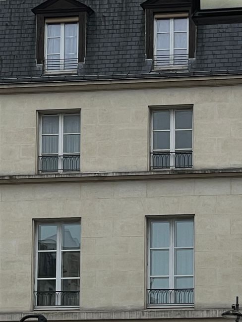 Close-up of a European building's facade featuring classic windows and architectural details.