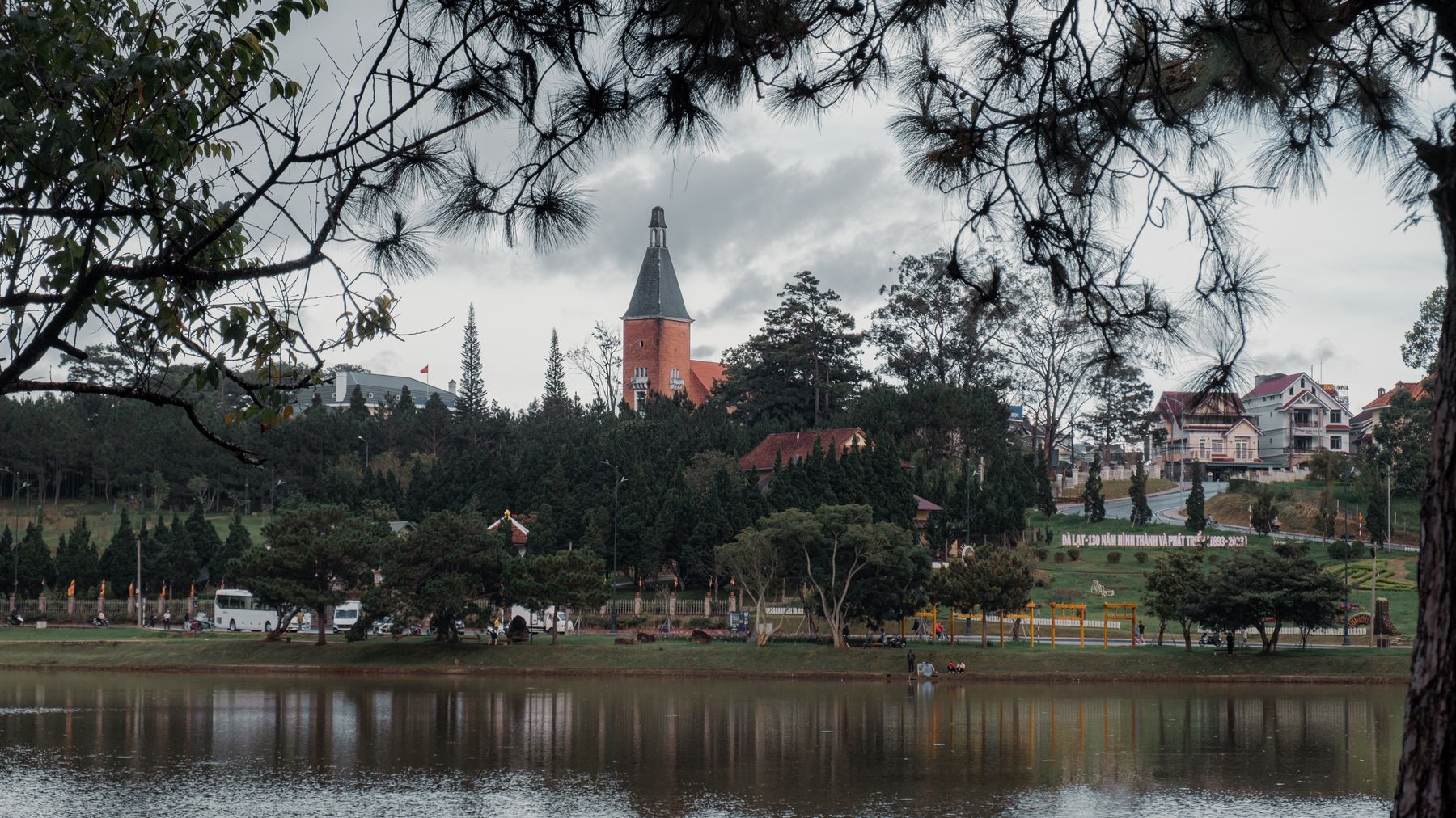 Beautiful view of a lake with iconic architecture and lush greenery in Da Lat, Vietnam.