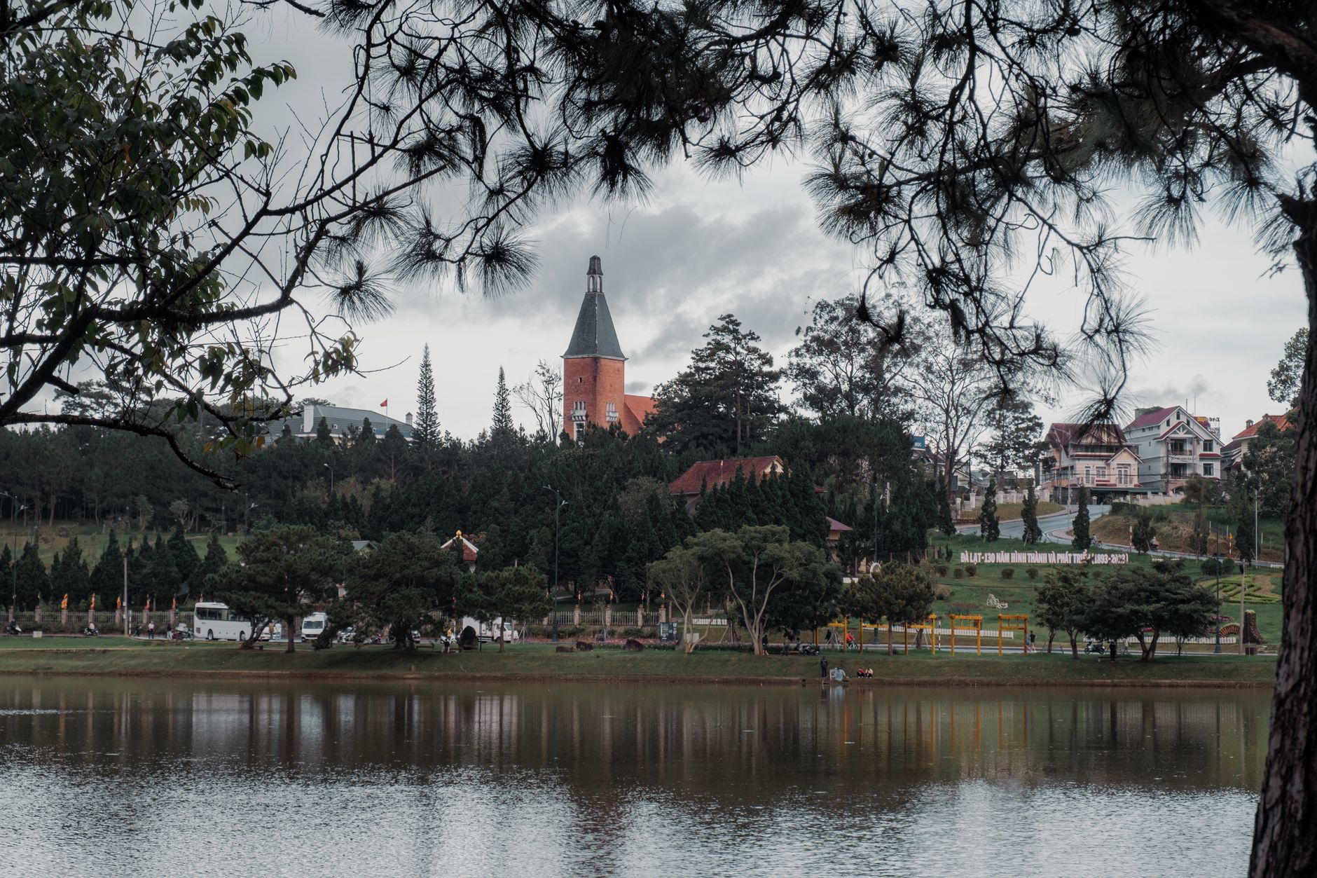 Beautiful view of a lake with iconic architecture and lush greenery in Da Lat, Vietnam.
