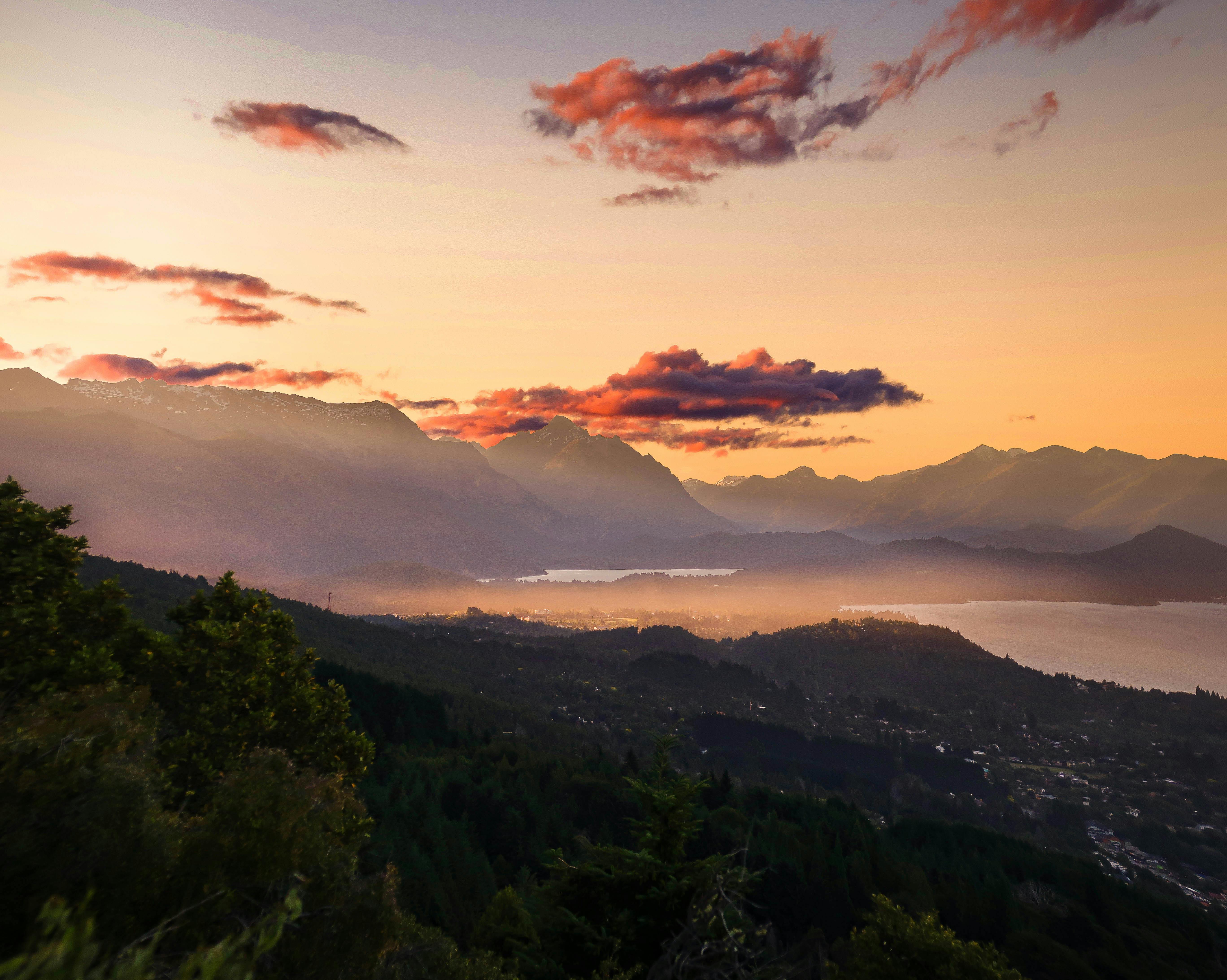 俯瞰宁静的山谷、山脉和充满活力的天空，日落景色令人惊叹