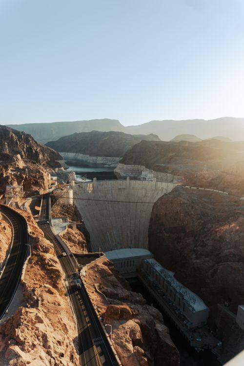 Free Breathtaking aerial view of Hoover Dam with surrounding landscapes at sunset. Stock Photo