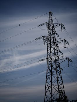 Silhouette of electricity transmission tower against a blue sky in Osijek, Croatia.