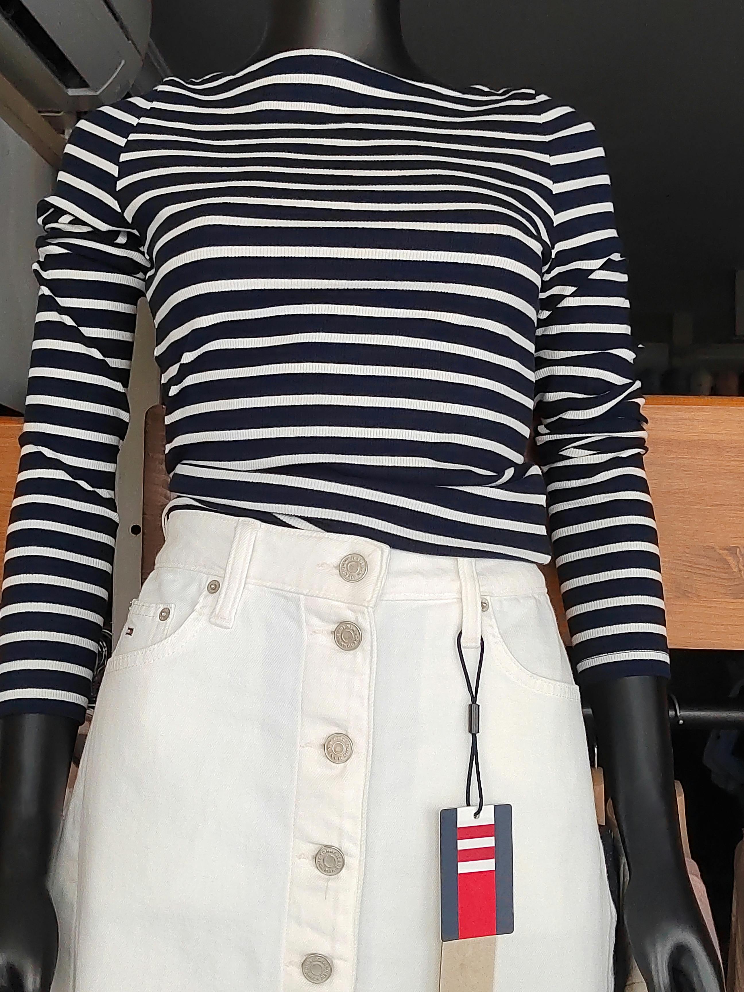 Mannequin displaying a blue and white striped blouse with a white denim skirt.