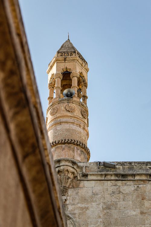 Free A close-up view of an ancient minaret against the clear sky, showcasing architectural details. Stock Photo