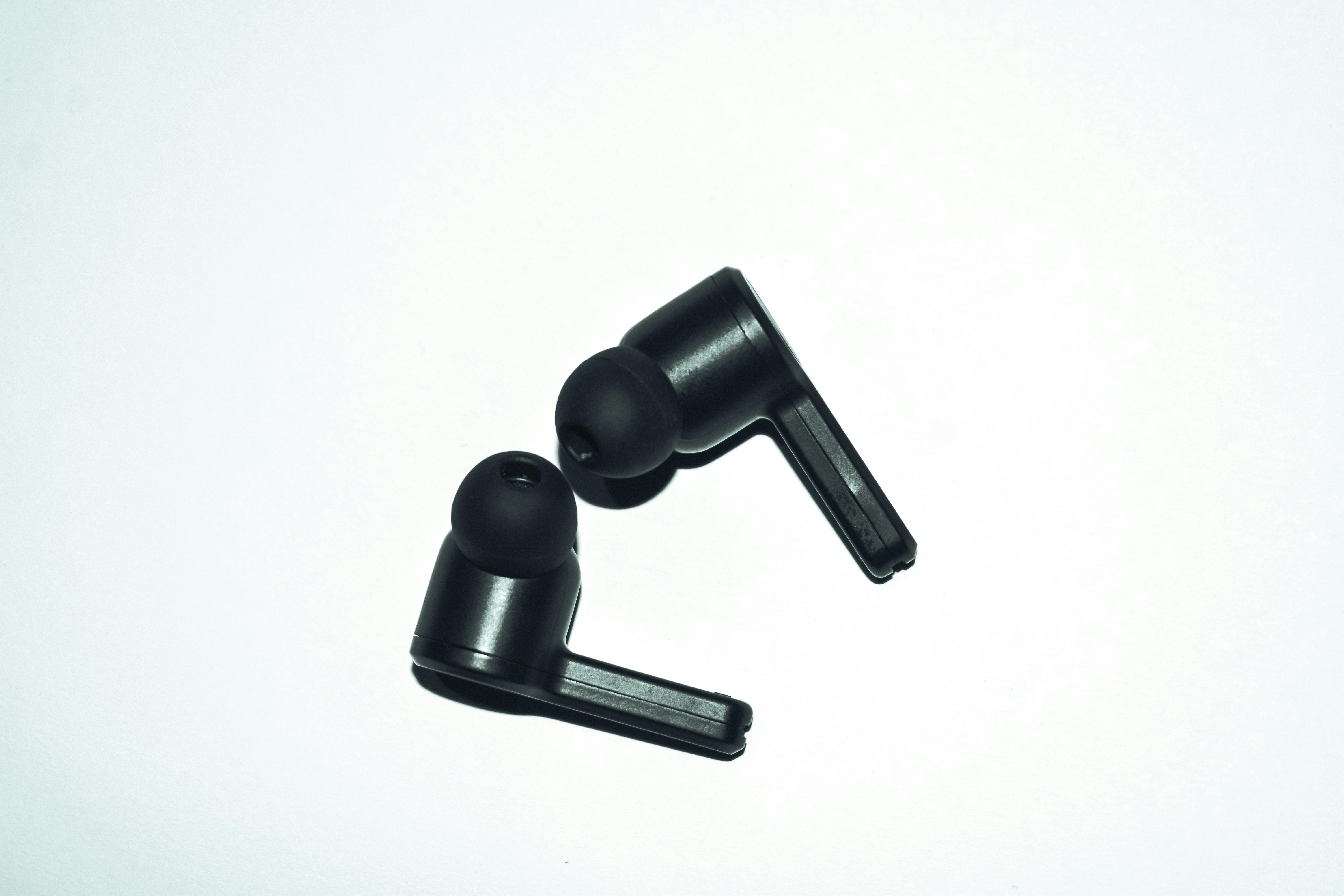 Close-up of stylish black earphones isolated on a white background, perfect for audio enthusiasts.