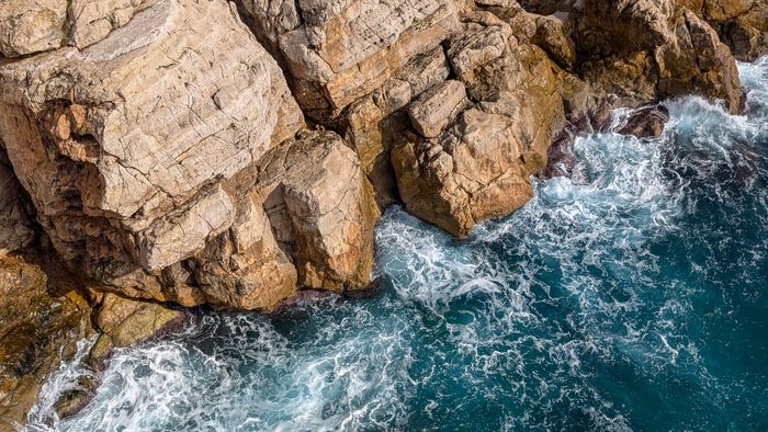 Waves crashing against rugged coastal cliffs — Robert Carnes on Pexels
