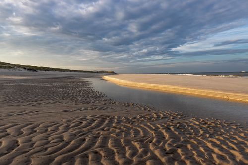 Free Serene tidal patterns on Kampen beach, Sylt under dramatic skies. Stock Photo