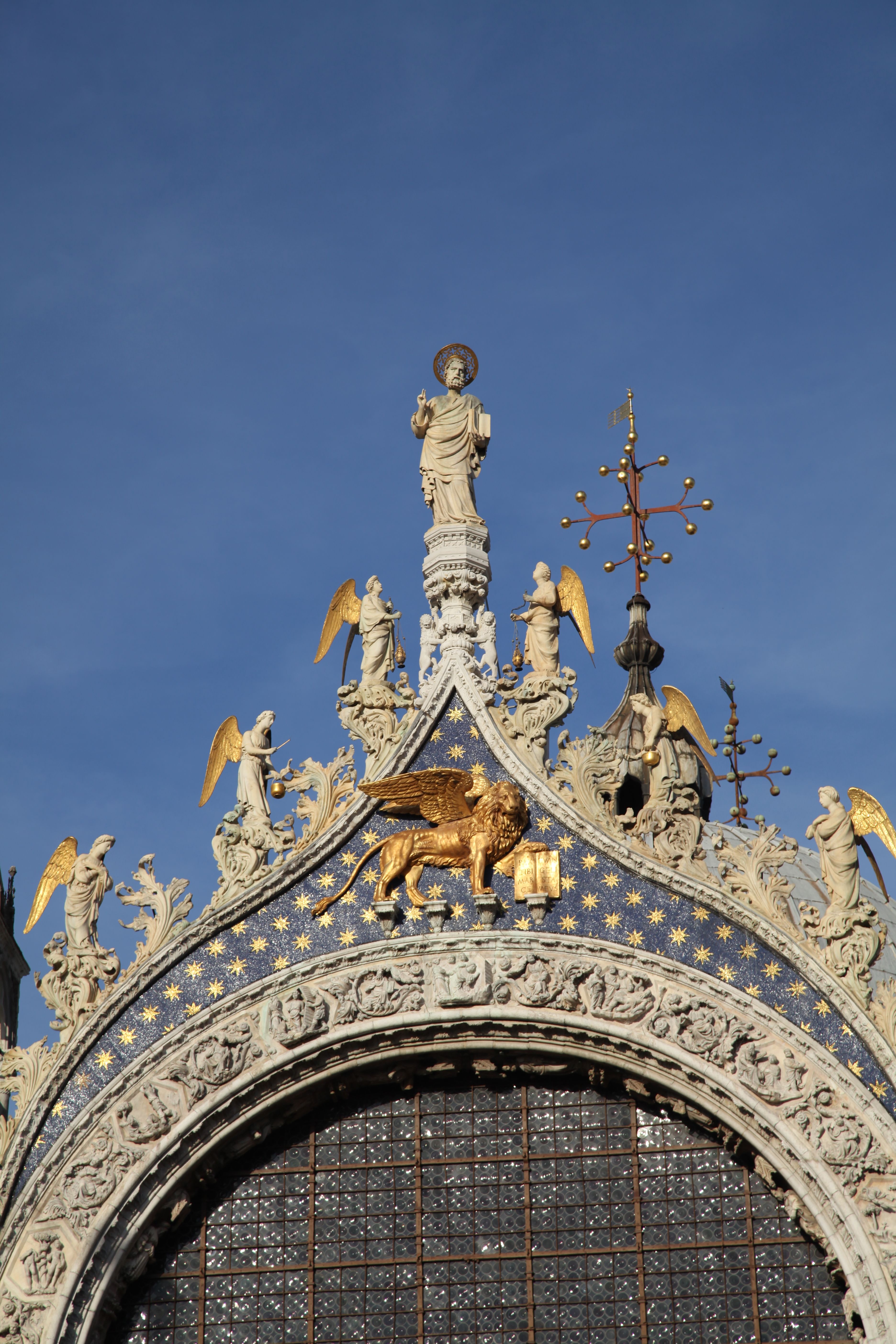 Intricate architecture and statues on St. Mark's Basilica's facade in Venice, Italy.
