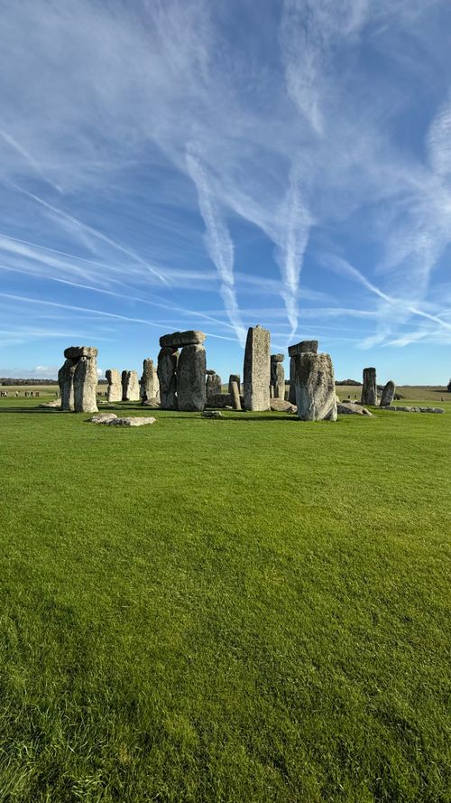 Free Stonehenge on a sunny day with vibrant green grass and blue sky, England. Stock Photo