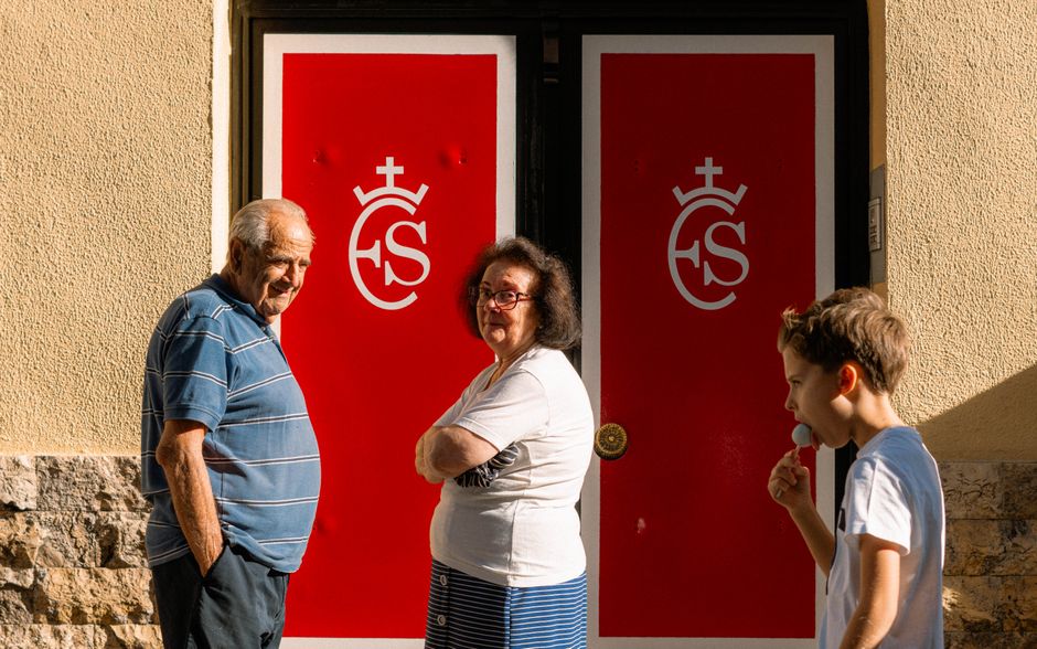 Una escena familiar en Madrid, con adultos y un niño junto a una vibrante puerta roja.