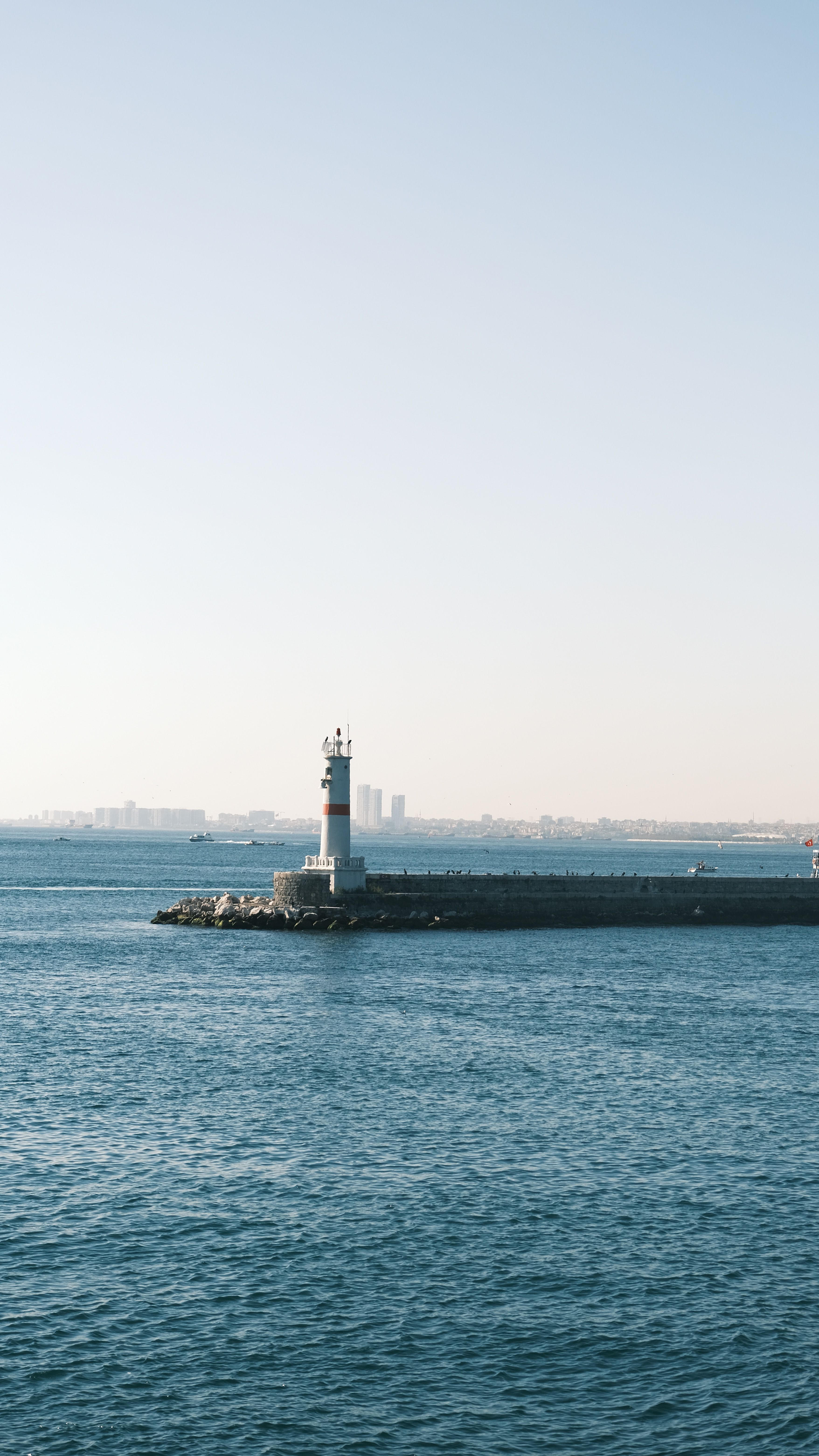 Red and White Lighthouse Near Body of Water · Free Stock Photo