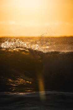 Captivating image of golden waves at sunset with splashing water, creating a warm and vibrant atmosphere.