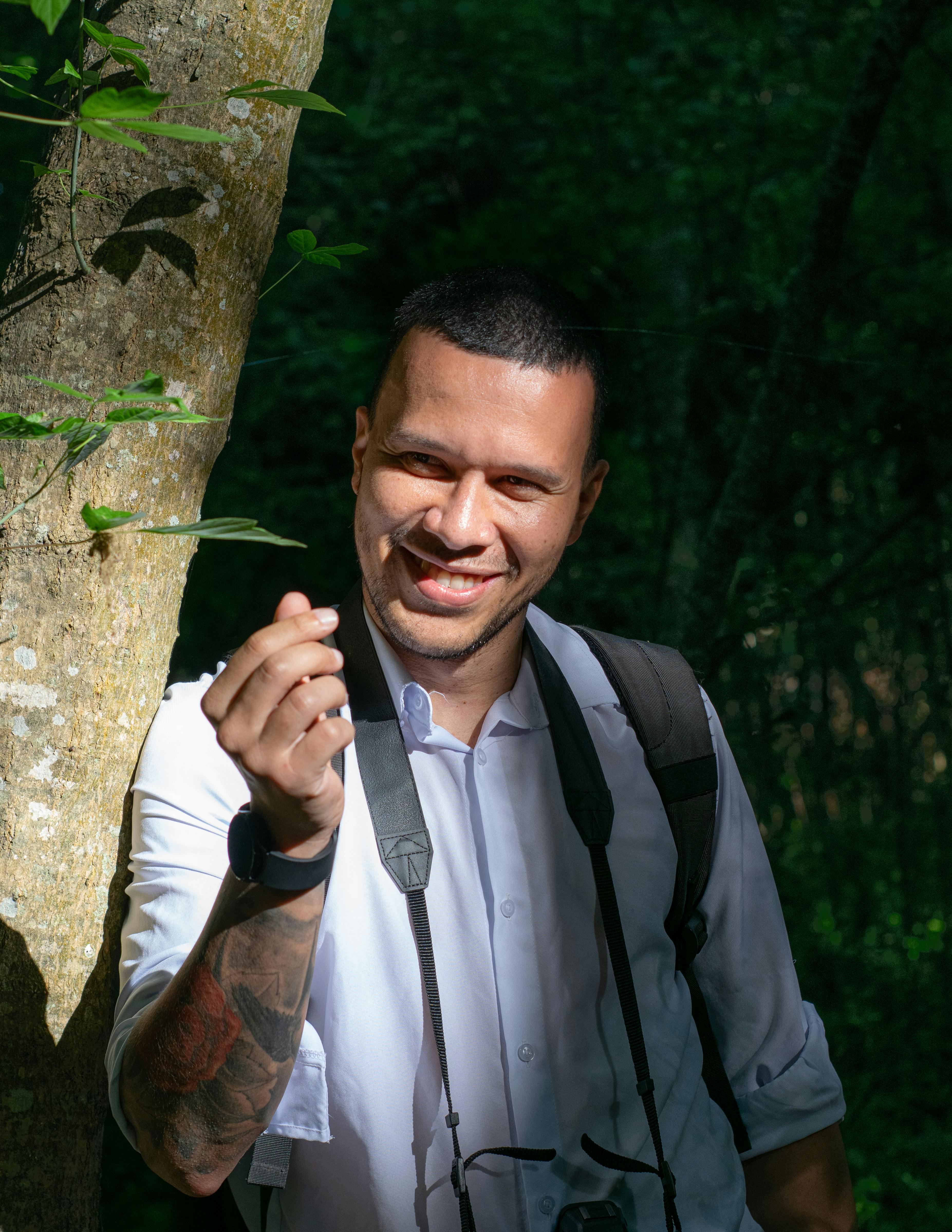 Smiling man in Chascomús nature setting holding a leaf.