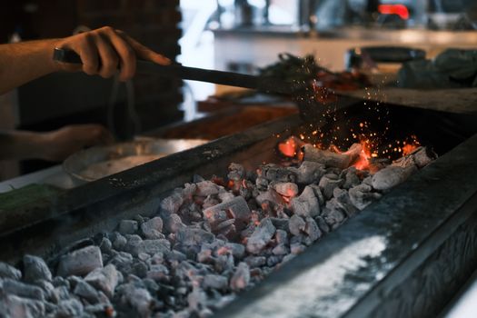 Close-up of glowing coals on a grill being prepared for a barbecue in Diyarbakır, Turkey.