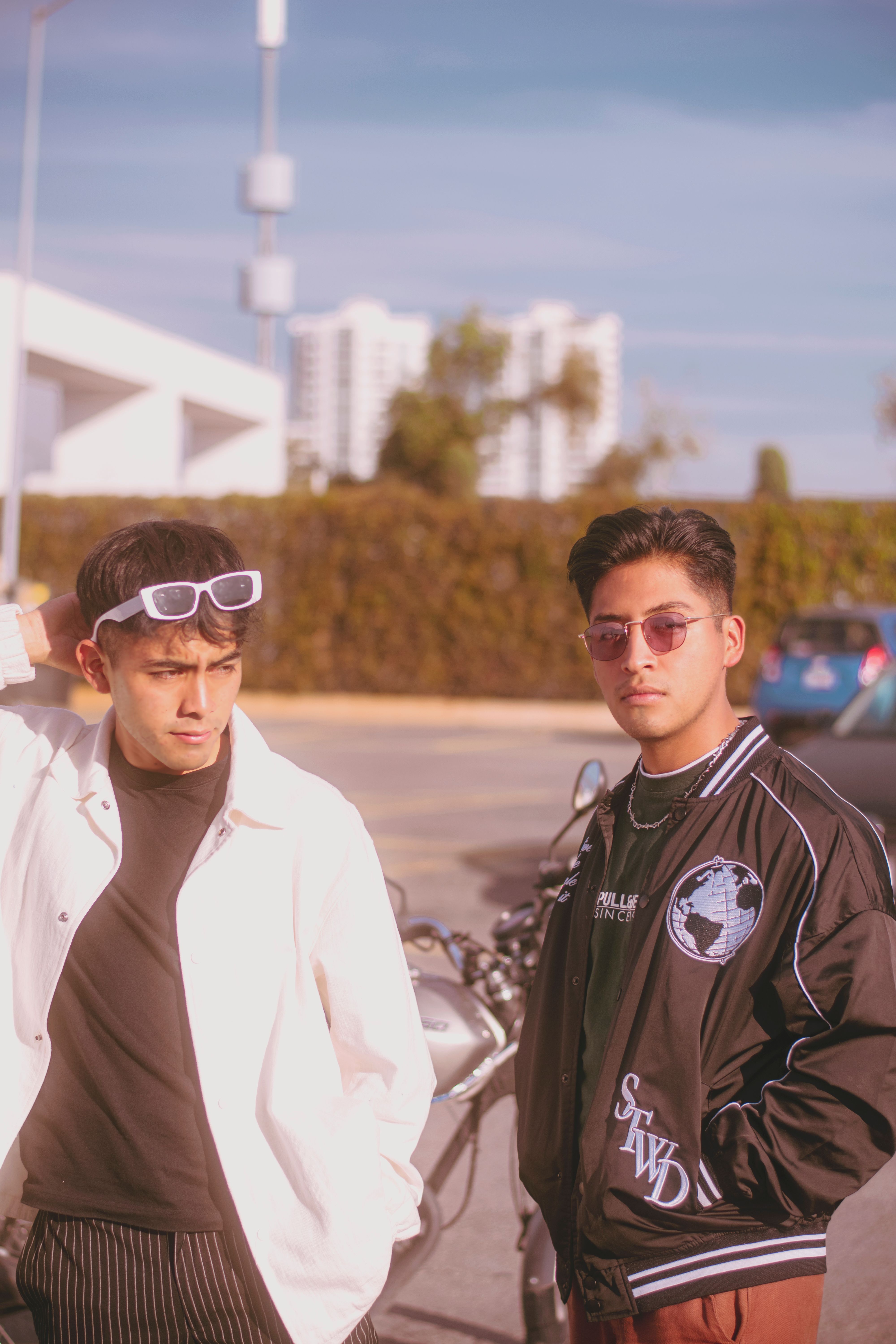 Fotomural Dos jóvenes con un estilo urbano moderno y gafas de sol al aire libre en un entorno de moda.