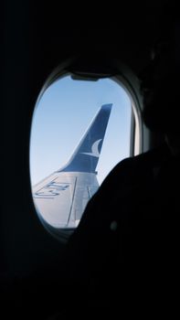 Passenger's view of an airplane wing through a window overlooking Ankara's skies.