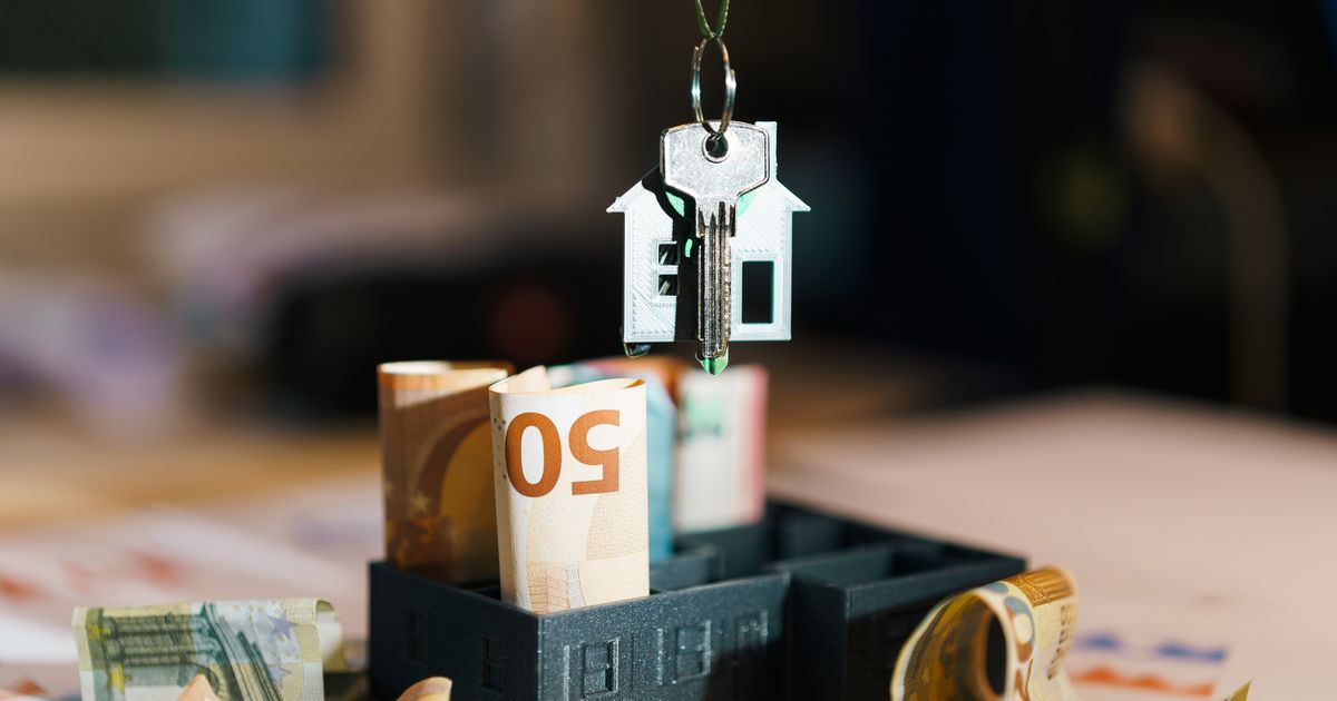 House key over Euro banknotes symbolizes real estate investment and financial planning.