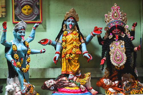 Free Colorful statues of Hindu goddesses Durga and Kali in a vibrant indoor setting. Stock Photo