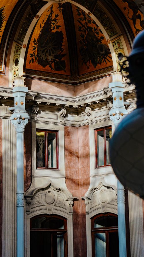 Free Sunlight illuminates intricate architectural details of a historic building's ornate facade. Stock Photo