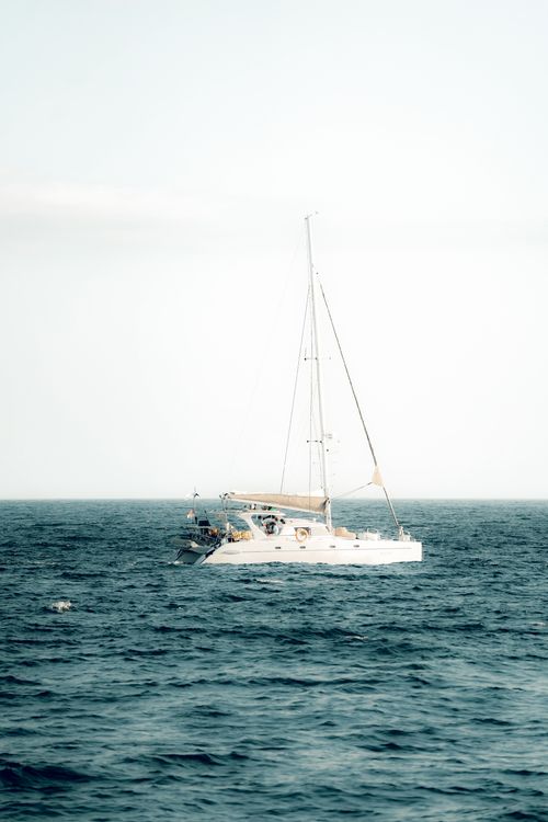 Free Tranquil white sailboat navigating the clear waters of Bali, Indonesia. Stock Photo