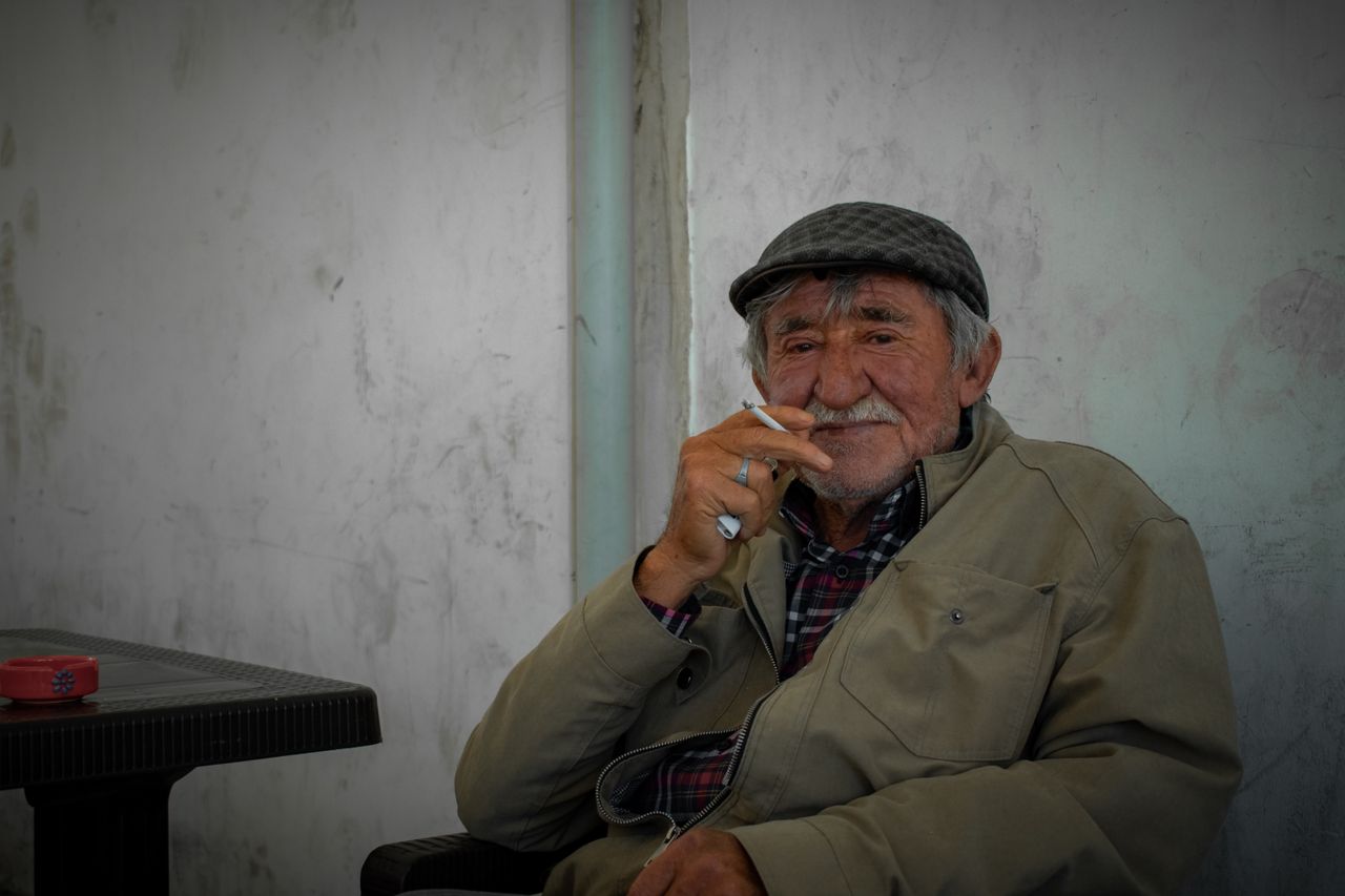 a wise looking senior man enjoys a quiet moment in istanbul capturing