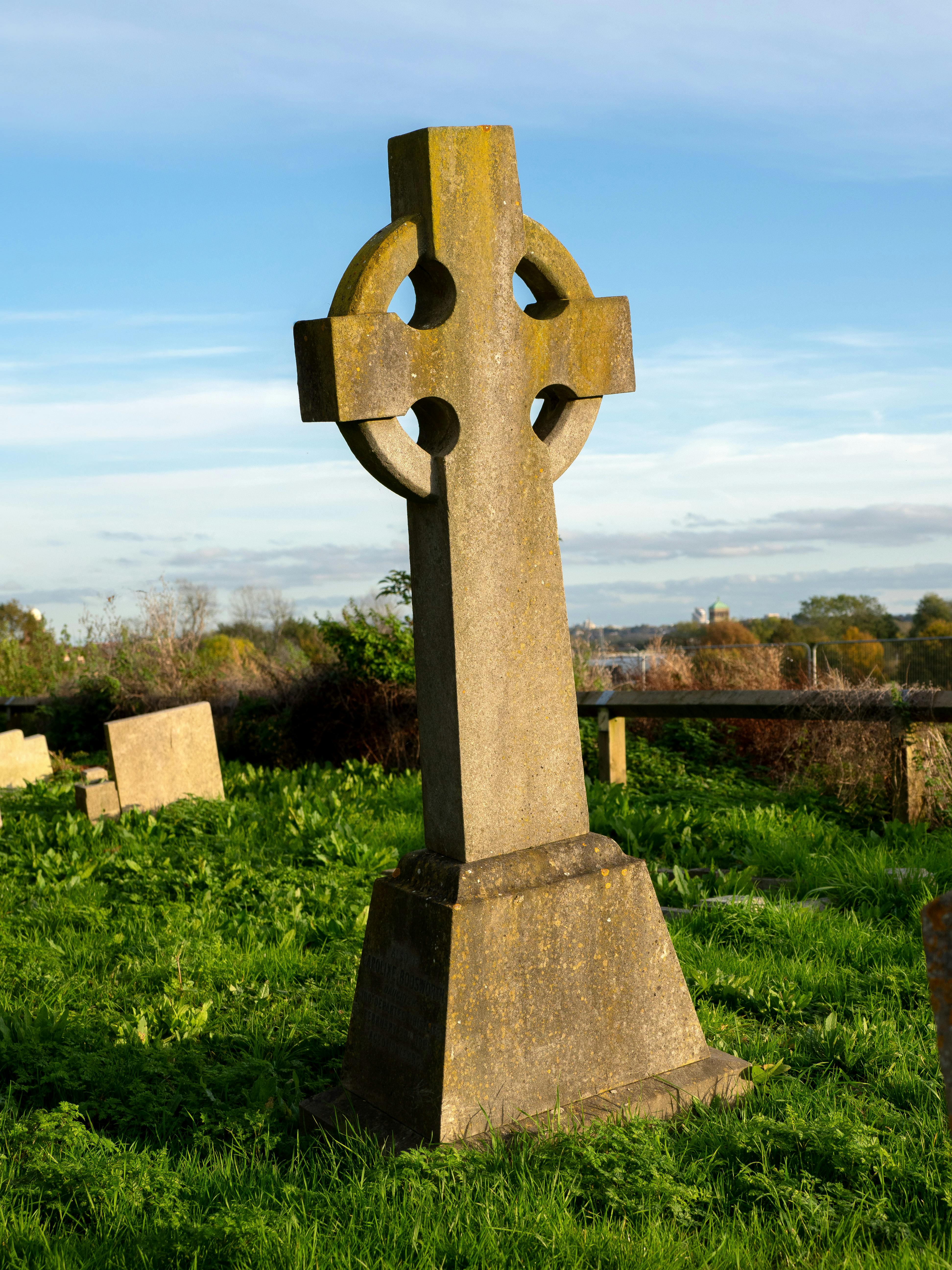 Celtic cross gravestone in St Mary's Church cemetery, Northolt, captured on a sunny day.