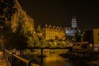 捷克克鲁姆洛夫的夜色迷人，城堡灯火通明，背景是宁静的河流