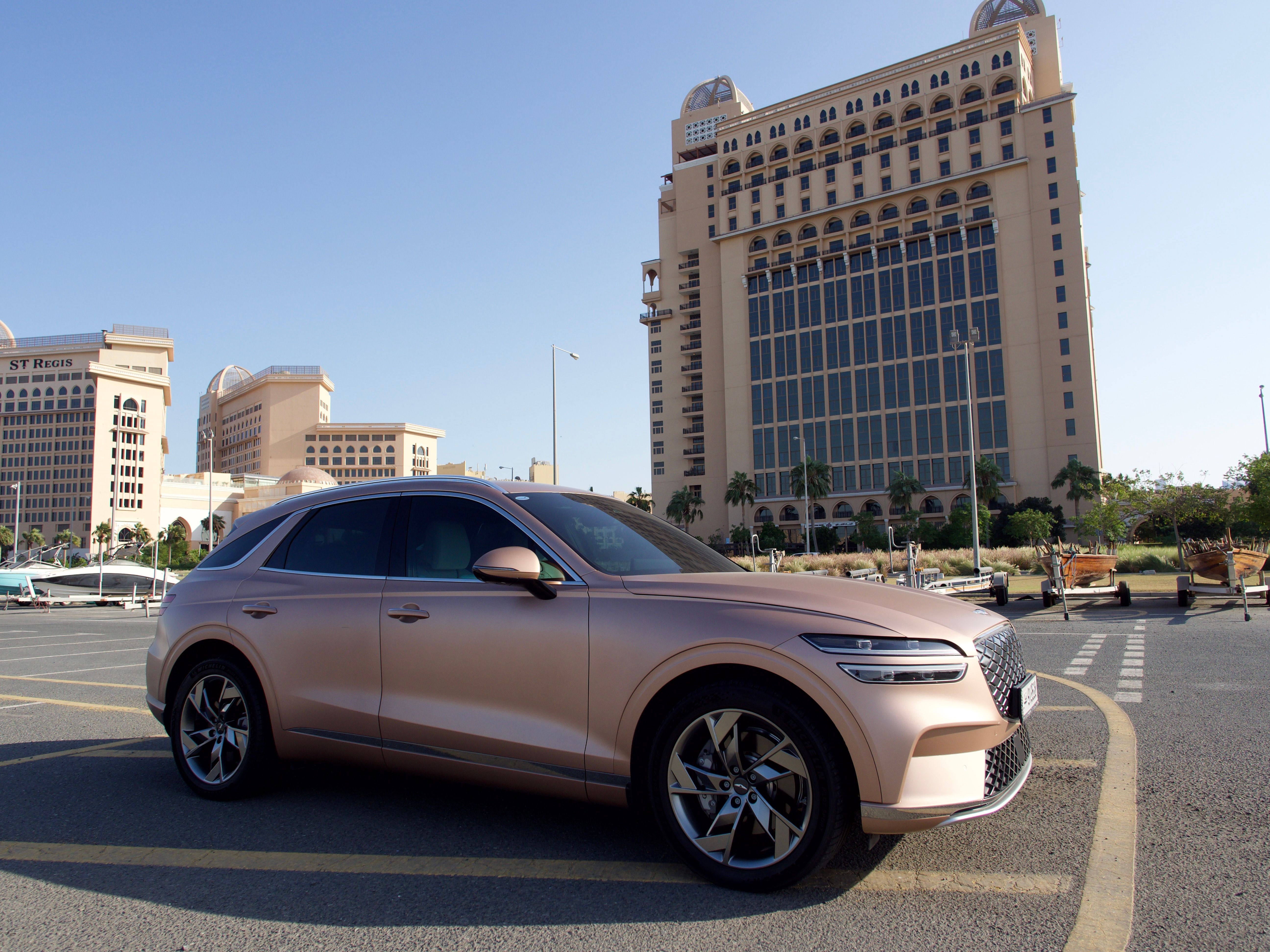 A luxury SUV parked in front of contemporary architecture.