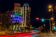 一张布拉格舞蹈屋的长曝光夜景照片，灯光明亮，带有光轨效果