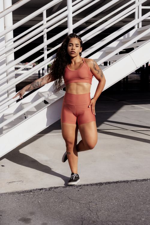 Free Athletic woman in activewear posing confidently outdoors with urban backdrop. Stock Photo