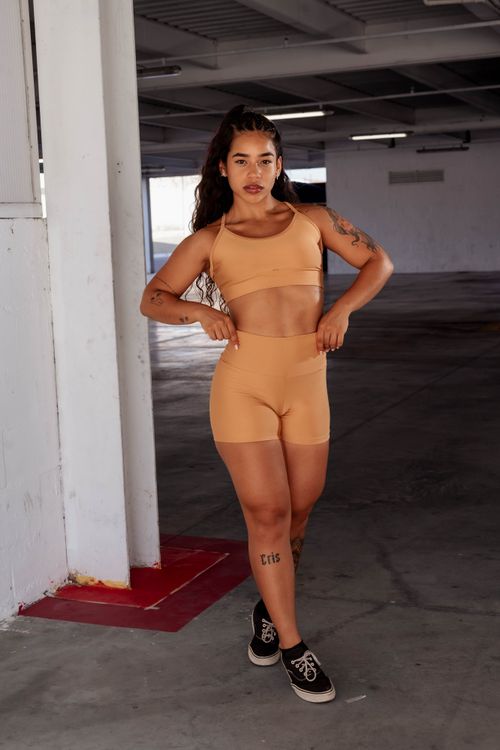 Free Young woman in workout attire posing confidently in an urban indoor setting. Stock Photo