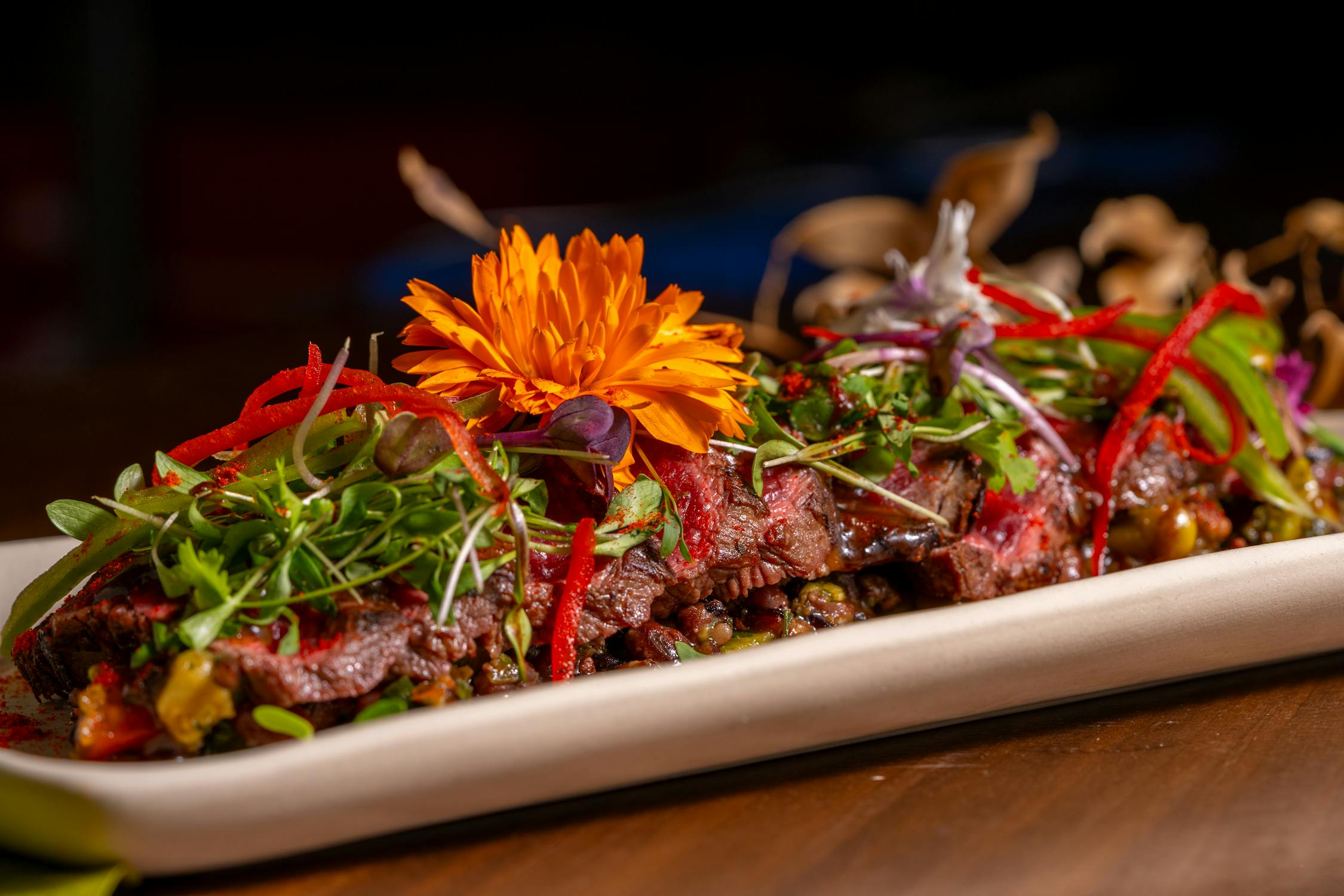 Gourmet Beef Dish with Edible Flowers and Peppers