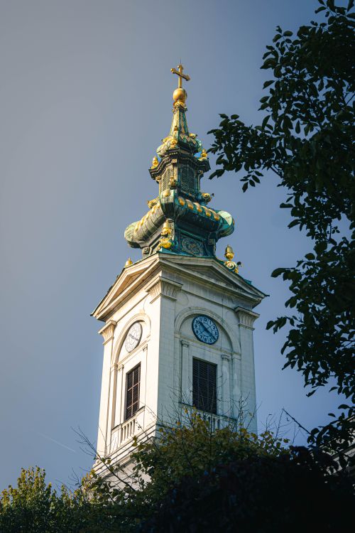 Free A detailed view of a historic church clock tower with intricate design against a clear sky. Stock Photo