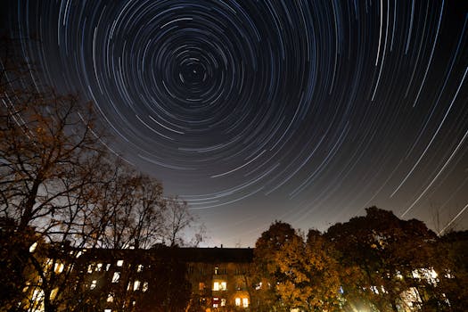 Beautiful long exposure capturing star trails over Berlin with silhouetted trees.