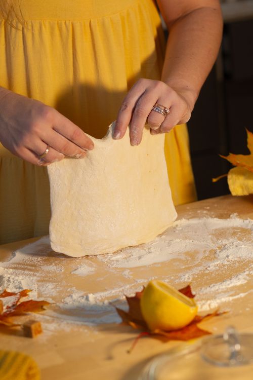 Free Close-up of hands working with dough, surrounded by fall leaves and a lemon. Stock Photo
