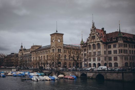 A picturesque view of Zurich's historic buildings along the river under an overcast sky.