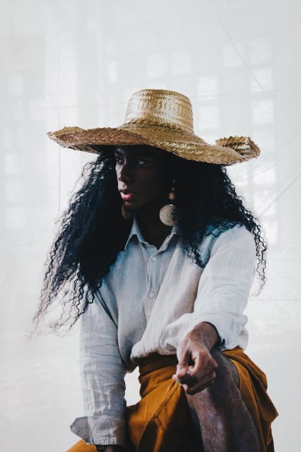 Elegant woman wearing a straw hat posing stylishly in Rio de Janeiro.