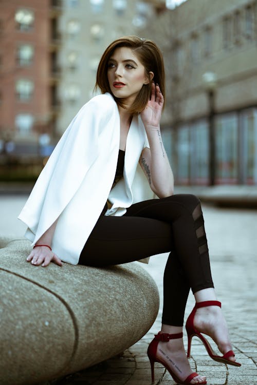 コンクリートブロックに座っている女性のセレクティブフォーカス写真
