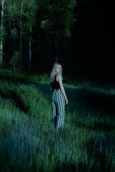 月光下的森林中，一位身着休闲装的金发女子摆着姿势，平添了几分神秘的光环