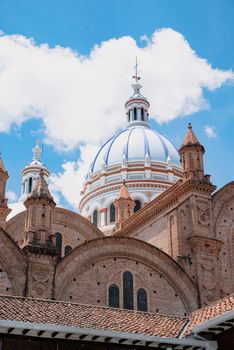 The iconic blue domes of the Cuenca Cathedral against a bright sky.
