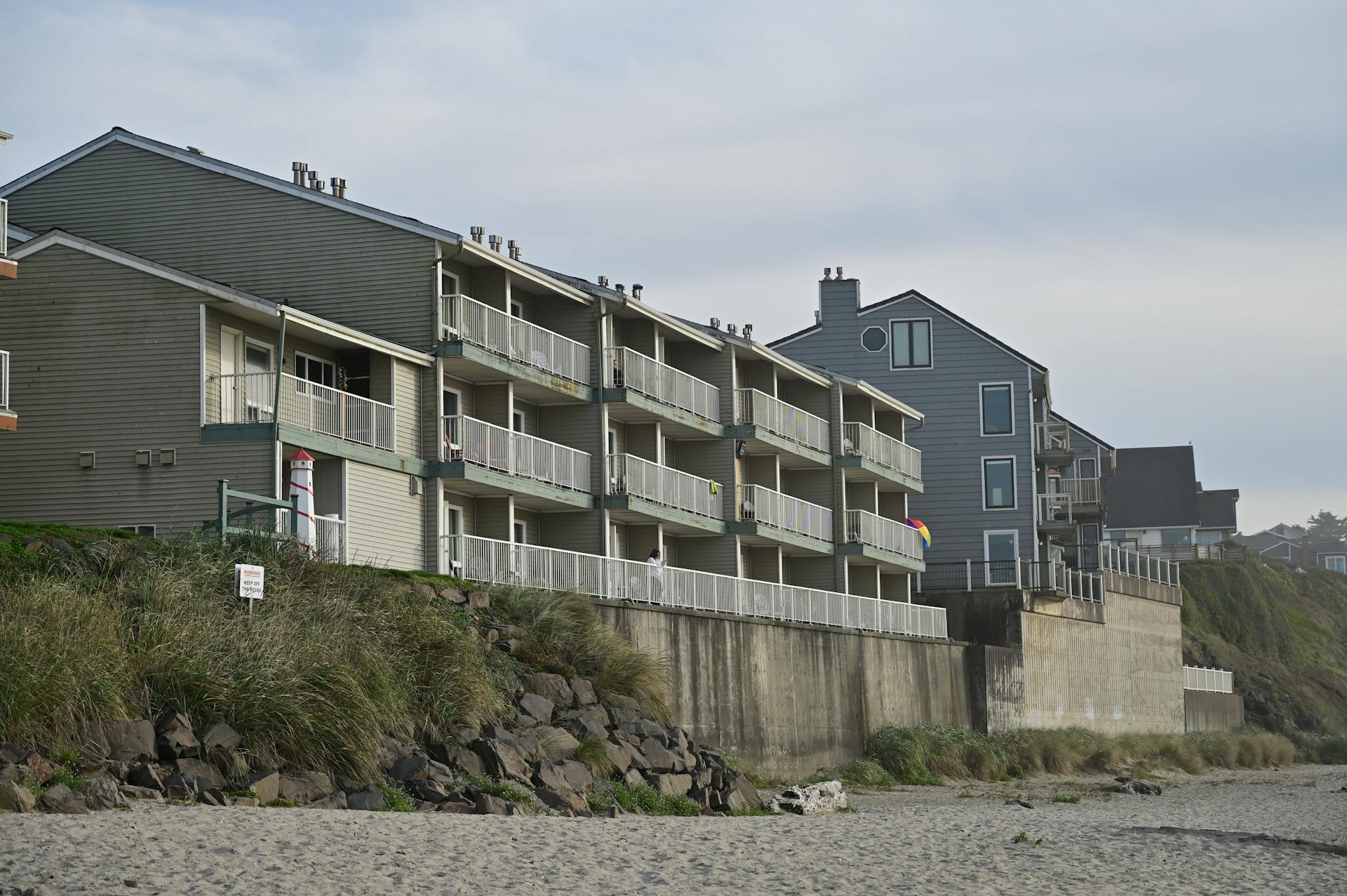 Oceanfront condos with balconies overlooking a sandy beach, perfect for vacation getaways.