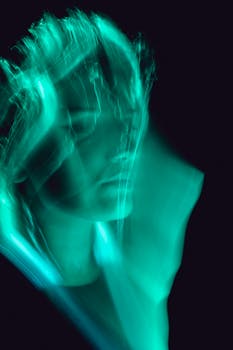 Artistic abstract portrait of a woman with neon green light effects creating motion blur.