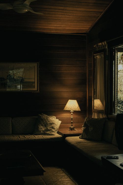 Free Rustic cabin living room with a cozy atmosphere, warm lamp light and wooden interior. Stock Photo