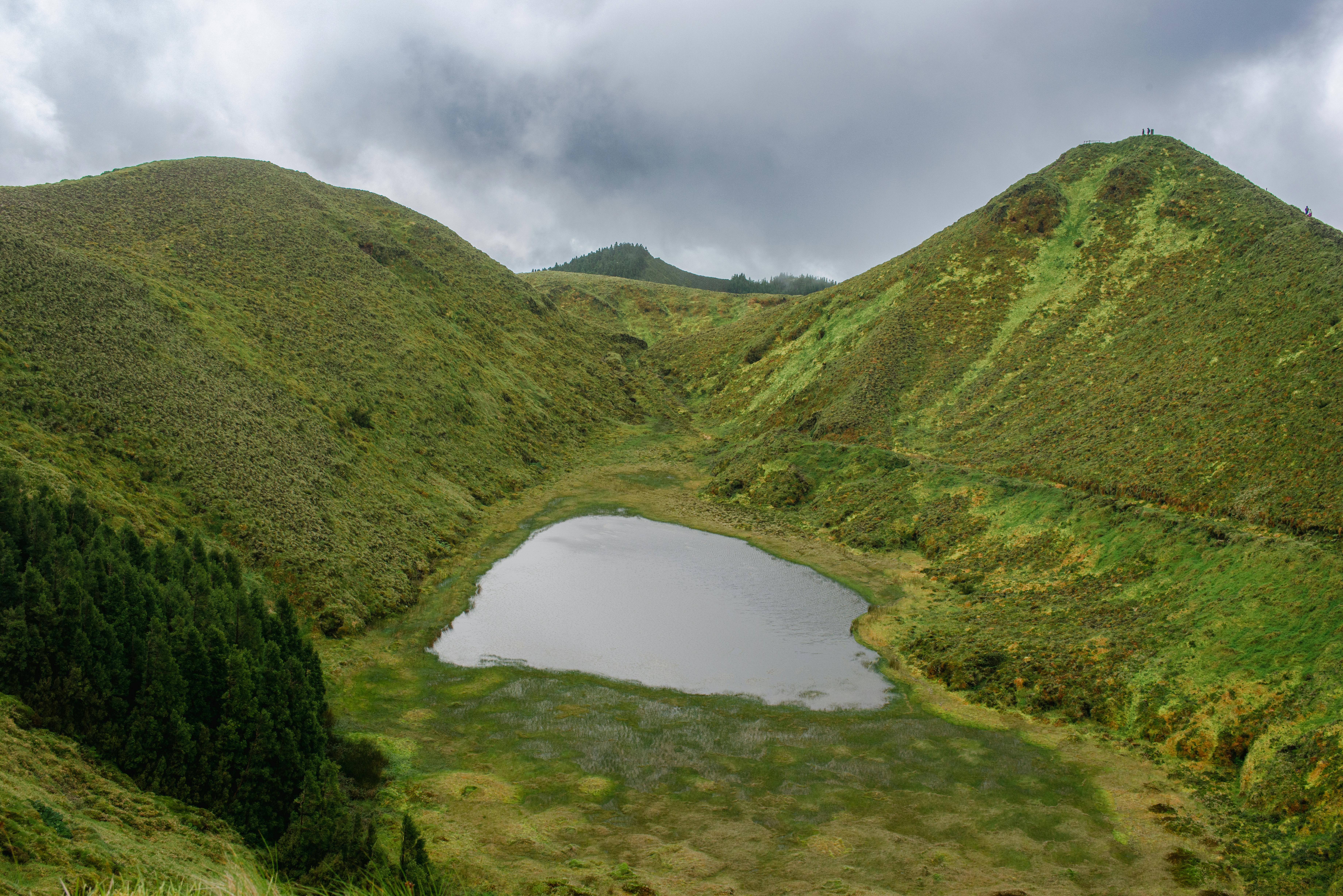 Lush green landscape with crater lake and mountains on Sao Miguel Island, Azores.