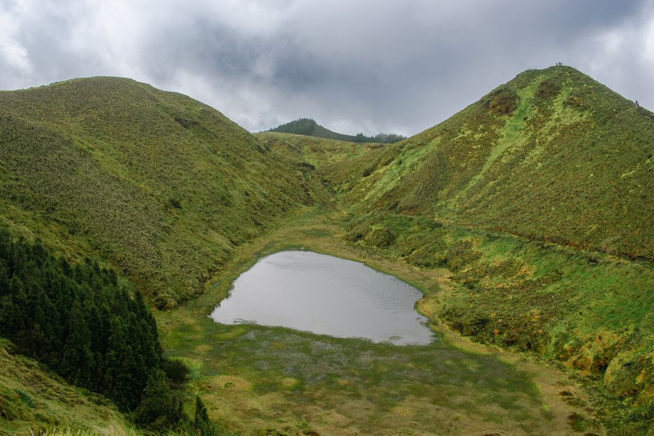 Lush green landscape with crater lake and mountains on Sao Miguel Island, Azores.