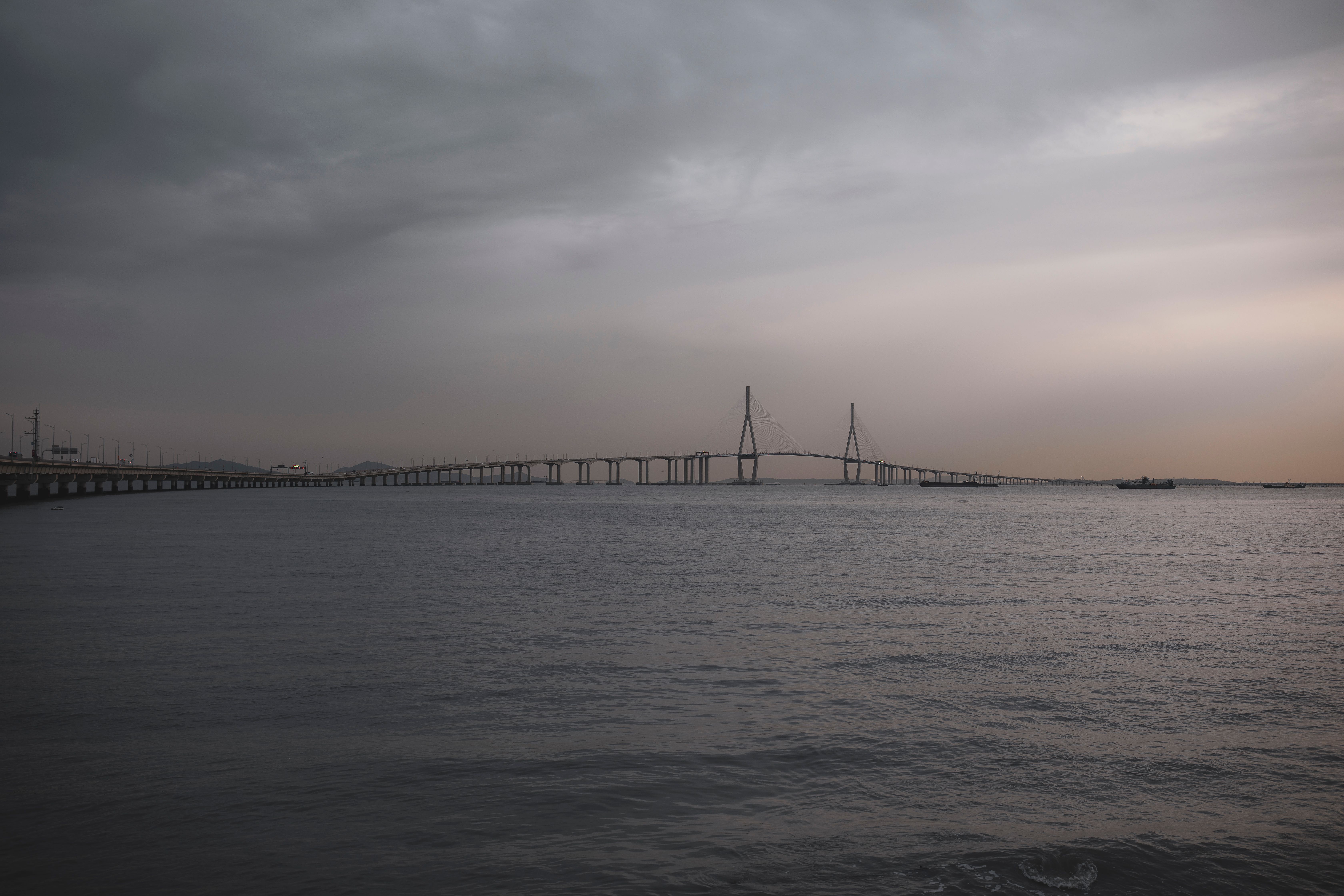 Dramatic Moody Bridge Over a Calm Sea · Free Stock Photo
