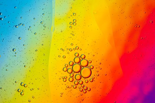 A vibrant abstract image featuring colorful oil and water bubbles in a multicolored gradient backdrop.