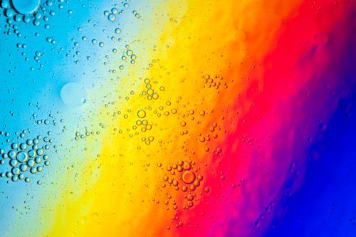 Free Colorful oil bubbles on a gradient spectrum background creating abstract patterns. Stock Photo