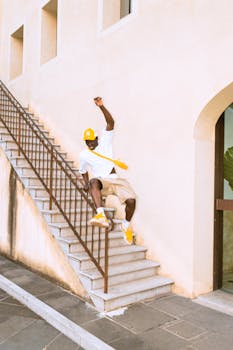 Young man skating down stairs in urban setting, exuding excitement and energy.